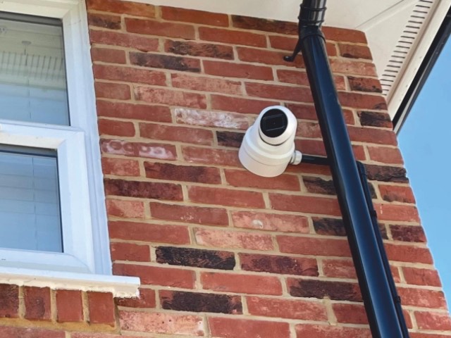External dome CCTV camera fitted to a brick wall