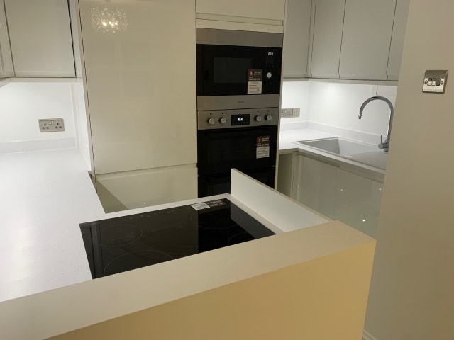 Modern kitchen with integrated oven, induction hob and under-cabinet lighting
