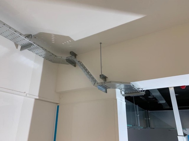 Galvanised cable tray carrying containment across a ceiling in a commercial unit
